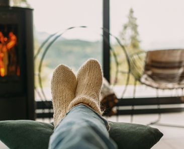 A person cozy and relaxing with a fireplace in the background.