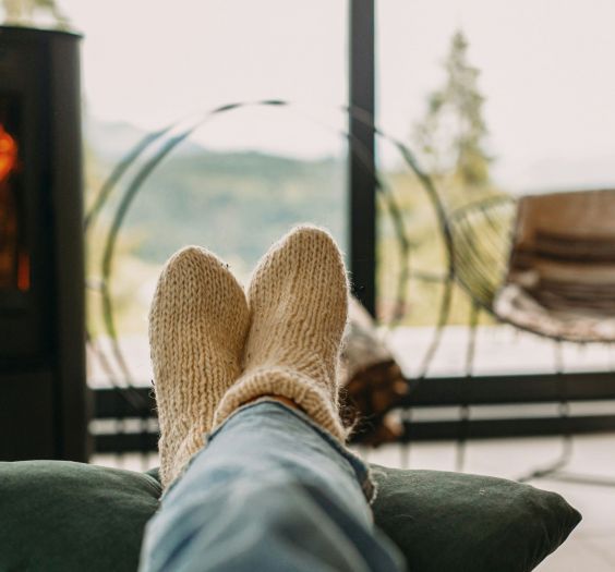 A person cozy and relaxing with a fireplace in the background.