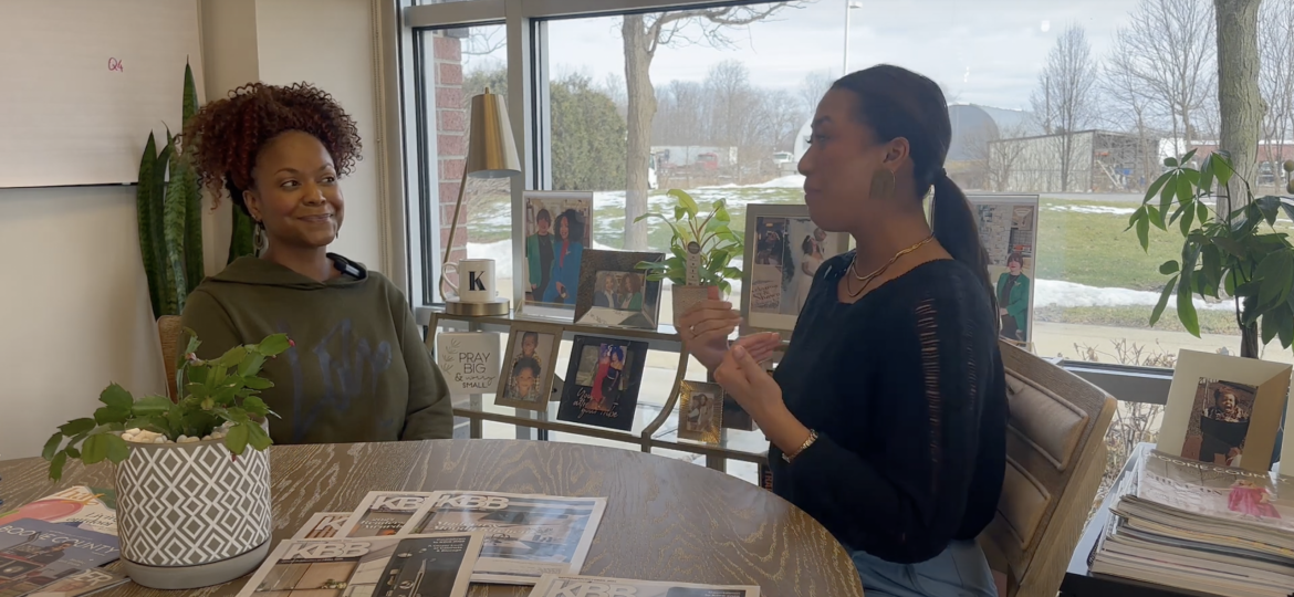 Arianna Cruz and Keianna Rae Harrison-Williams sitting at a table together talking.