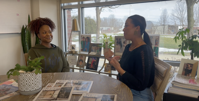 Arianna Cruz and Keianna Rae Harrison-Williams sitting at a table together talking.