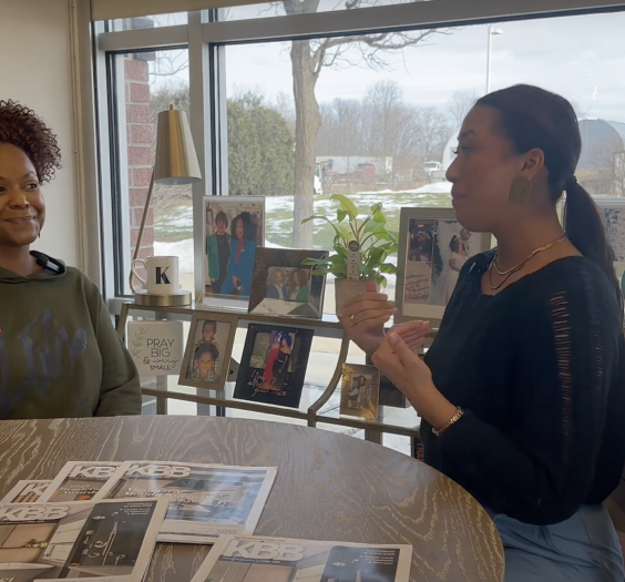 Arianna Cruz and Keianna Rae Harrison-Williams sitting at a table together talking.