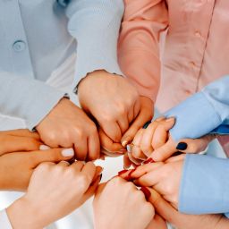 women's hands holding one another in a circle