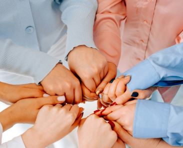 women's hands holding one another in a circle