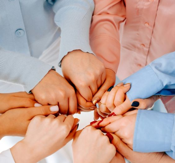 women's hands holding one another in a circle