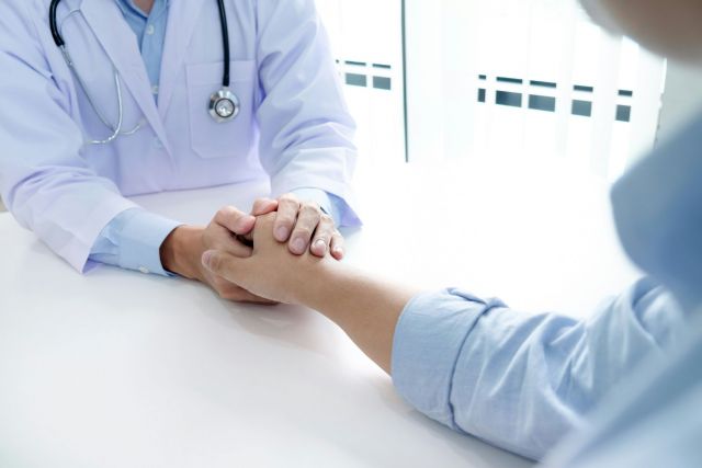 Doctor holding a patient's hand.