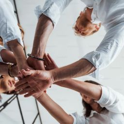undershot view of hands coming together in a circle