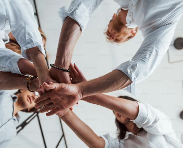 undershot view of hands coming together in a circle