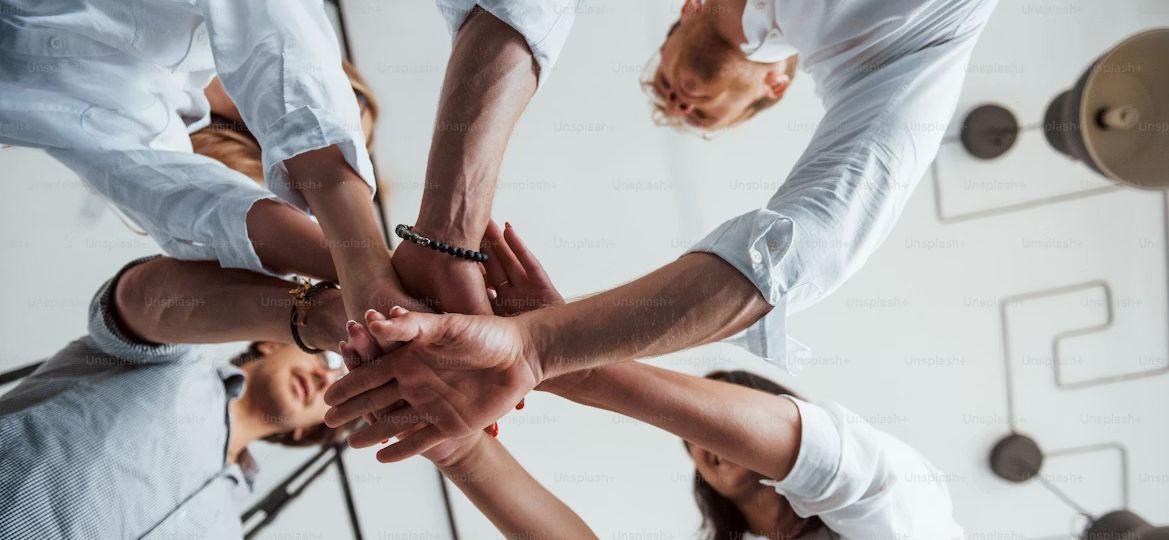 undershot view of hands coming together in a circle