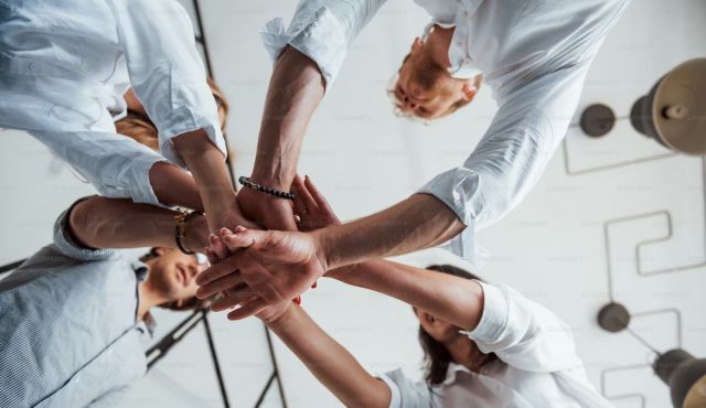 undershot view of hands coming together in a circle