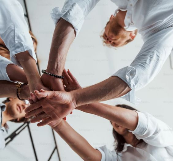 undershot view of hands coming together in a circle