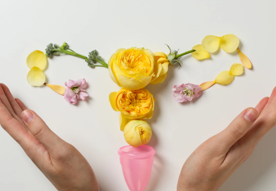 hands cupping flowers organized to look like a uterus