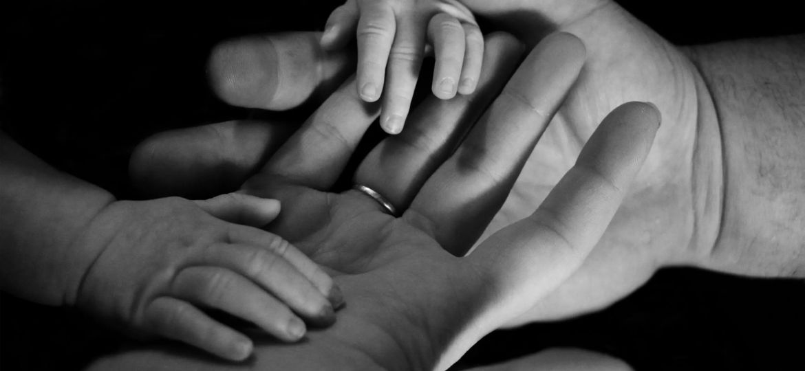 a mother's hands holder her baby's hands