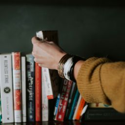 Summer Reads - Person placing a book back into the line-up.