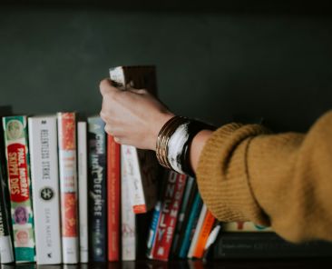 Summer Reads - Person placing a book back into the line-up.