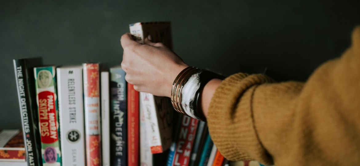 Summer Reads - Person placing a book back into the line-up.