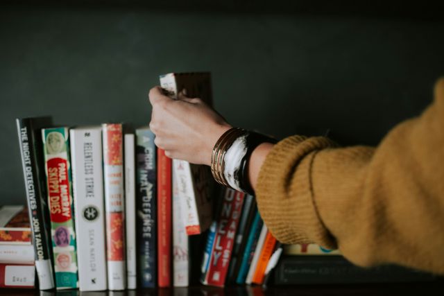 Summer Reads - Person placing a book back into the line-up.