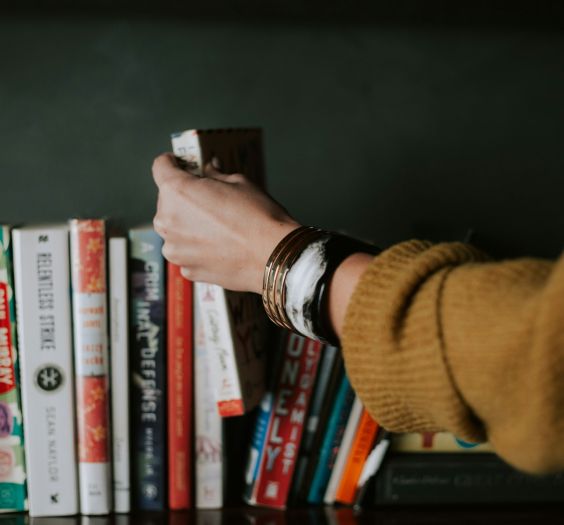 Summer Reads - Person placing a book back into the line-up.