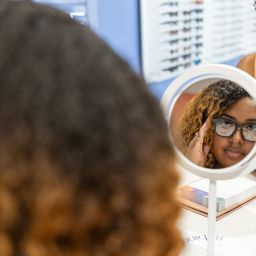 Woman looking at new glasses in the eye doctor shop.