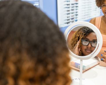 Woman looking at new glasses in the eye doctor shop.