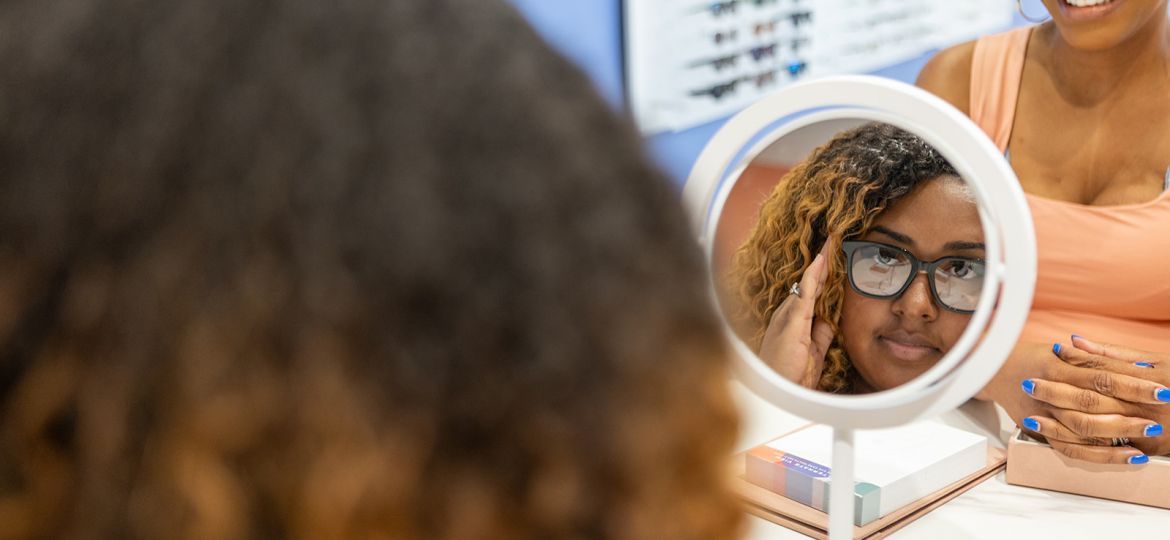 Woman looking at new glasses in the eye doctor shop.