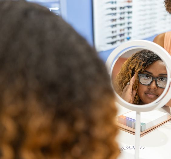 Woman looking at new glasses in the eye doctor shop.