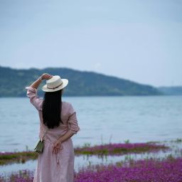 woman in a hat overlooking a body of water
