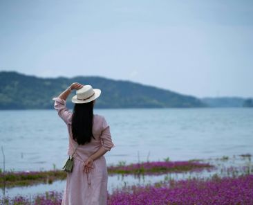 woman in a hat overlooking a body of water