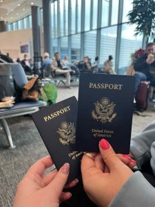 2 passports being held up in an airport terminal
