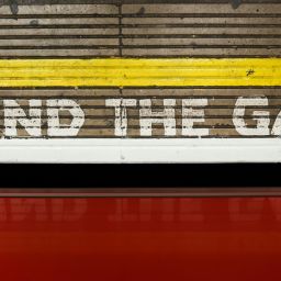 "Mind the Gap" painted on a wall at a train station