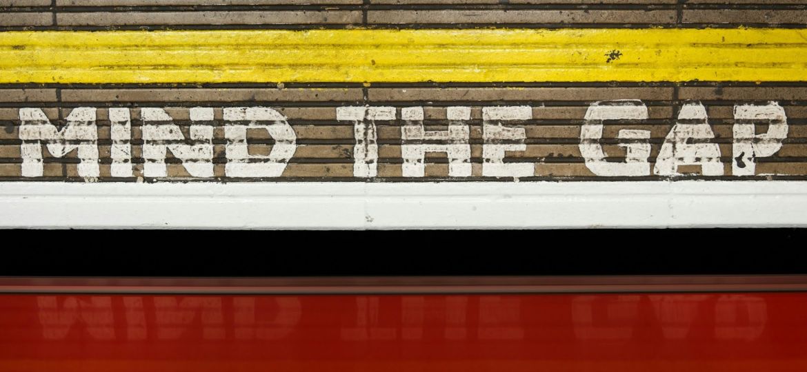 "Mind the Gap" painted on a wall at a train station