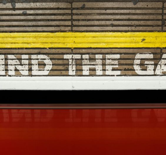 "Mind the Gap" painted on a wall at a train station