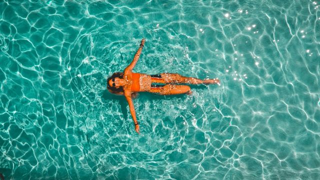 overhead view of a woman floating in a clear body of water