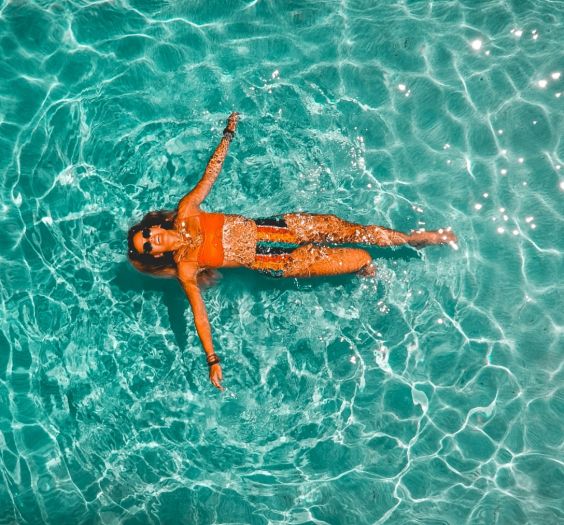 overhead view of a woman floating in a clear body of water