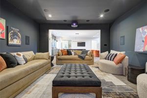 Inside view of a living room with dark walls and a white-painted room in the distance