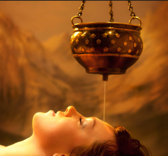 Shirodhara therapy - woman lying down as oil drips on her forehead