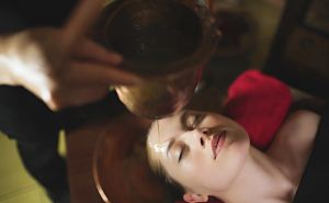 overhead shot of a woman in the middle of Shirodhara therapy