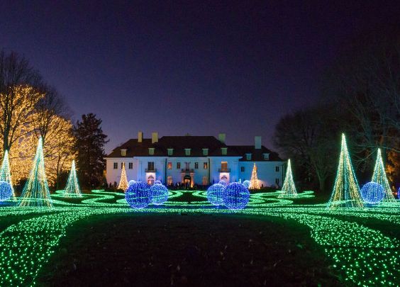 A lighted lawn in front of a large manor at Winterlights