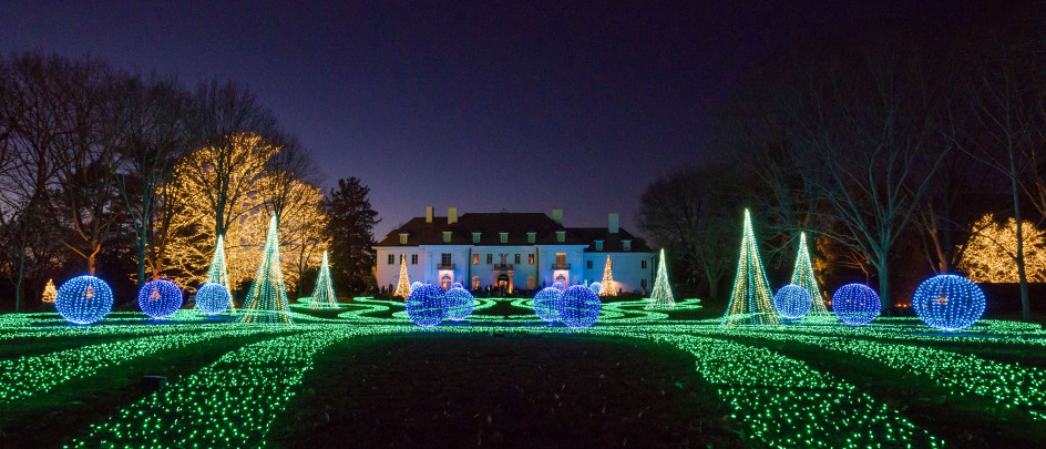 A lighted lawn in front of a large manor at Winterlights